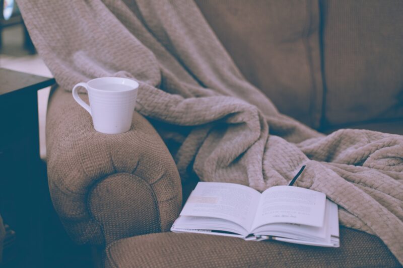 A book, a blanket, and a coffee