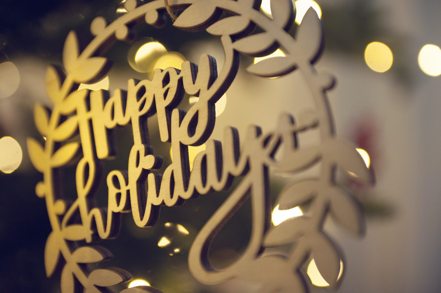 A close-up of an ornament that says, "Happy Holidays."