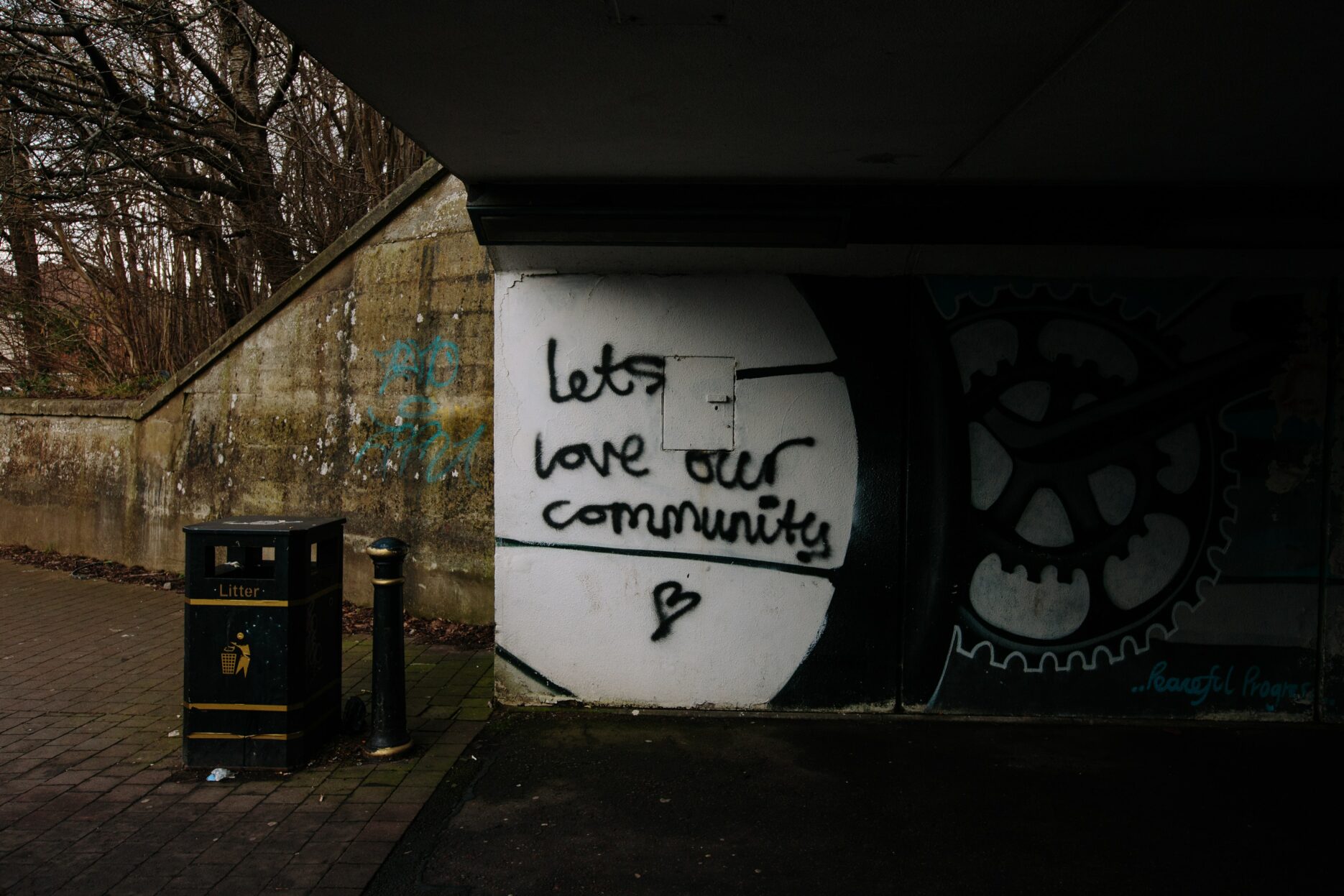 Graffiti on a stucco wall reads, "Let's love our community."