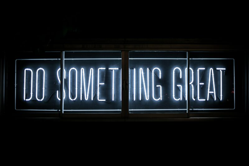 A black background punctuated by the phrase, "Do Something Great" in blue neon letters.