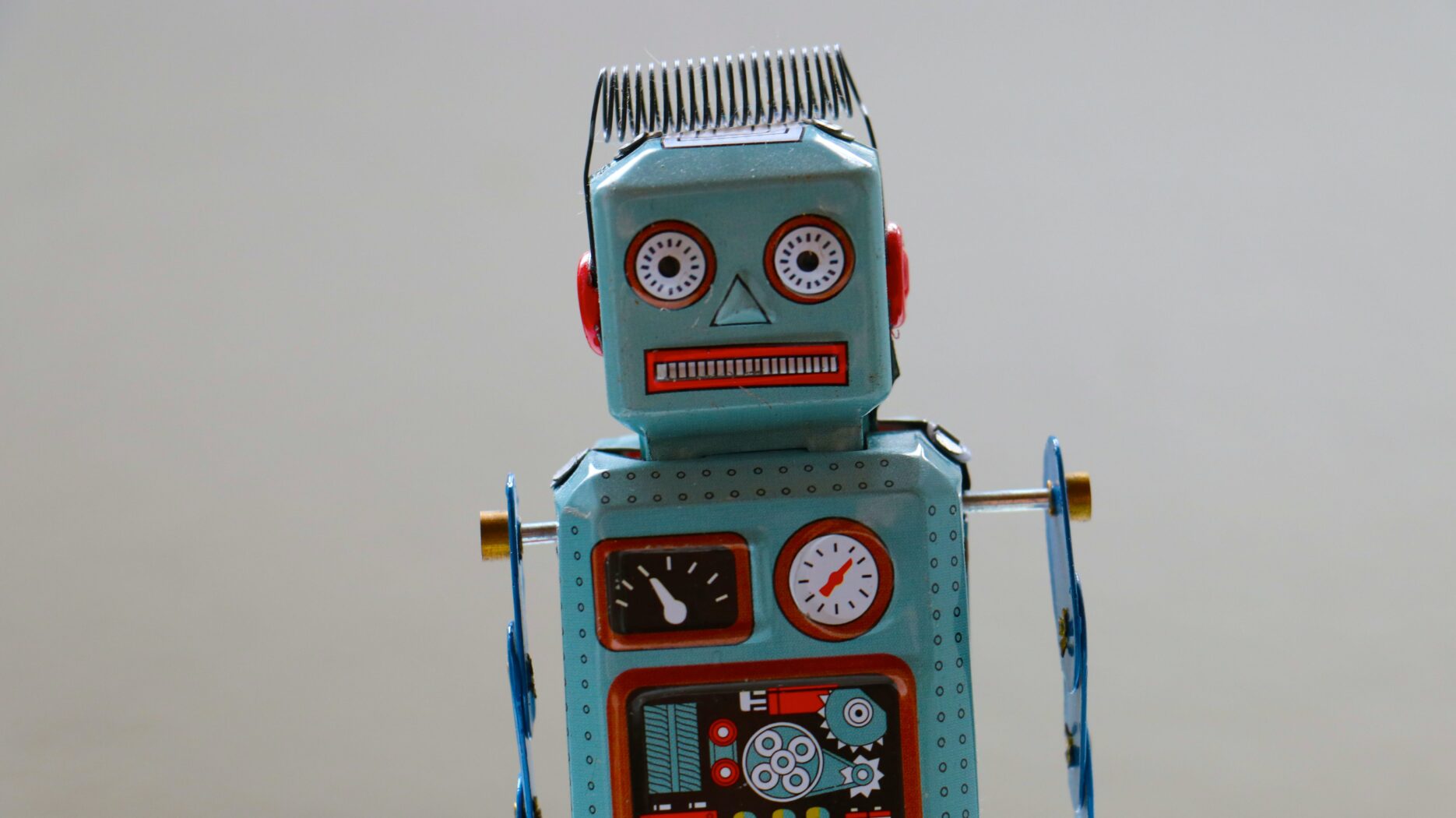 A 60s-style tin robot toy with a confused look on his face peers into the camera.